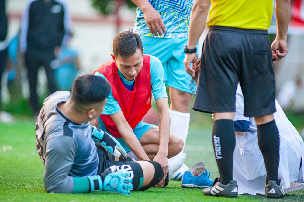 on-field sports physiotherapists treating an ankle injury in soccer