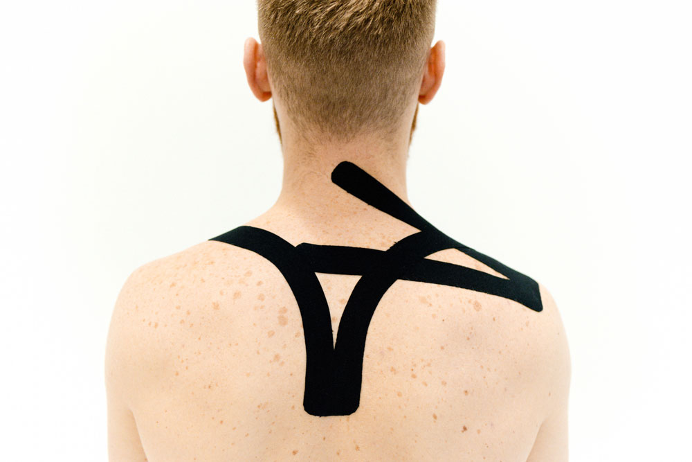 sports physiotherapists taping shoulder injury